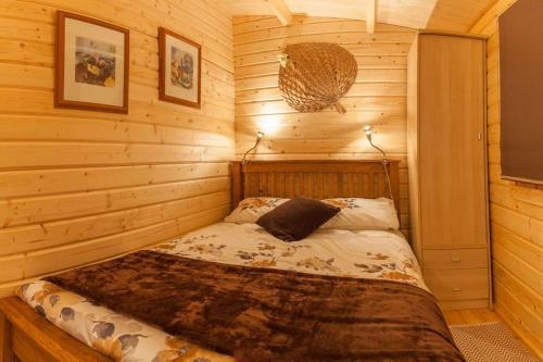 a bedroom with a bed in a log cabin at Family friendly sunny Log Cabin in Wimborne Minster