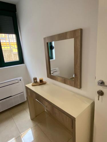 a bathroom with a vanity with a mirror on the wall at Tondo in Tivat