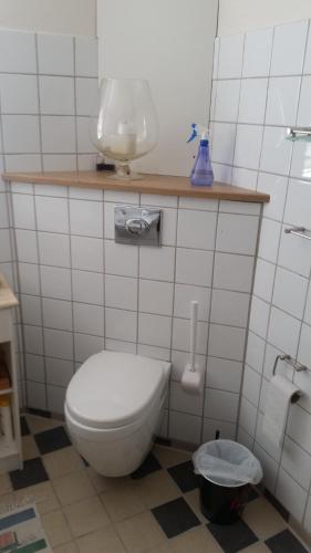 a bathroom with a toilet and a bowl on a shelf at Hvil og Sov. in Grindsted