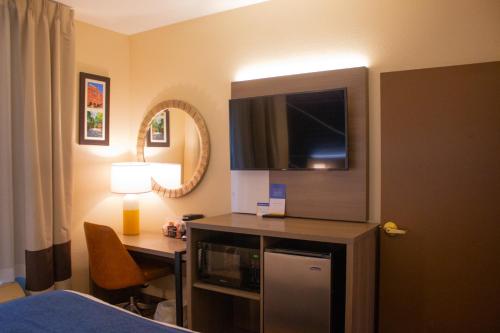 a hotel room with a desk and a tv and a room at Comfort Inn & Suites Geneva- West Chicago in Geneva