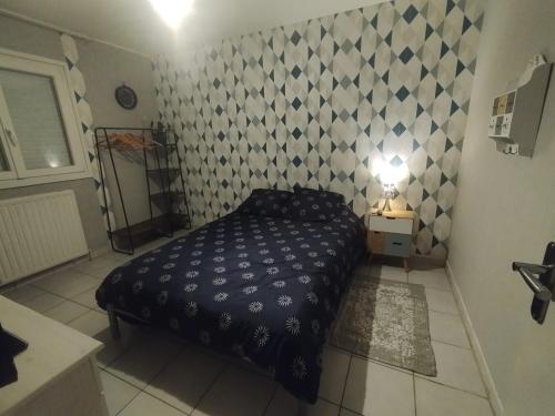 a small bedroom with a bed and a wall at Chambre chez l'habitant avec Sdb et WC privatifs in Marnay-sur-Seine