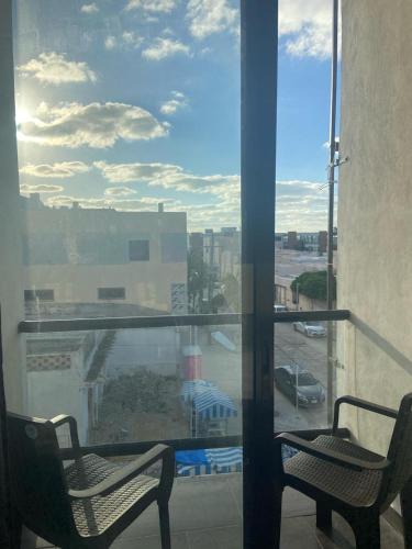 a window with two chairs and a view of a parking lot at REGMAR Progreso Yucatán in Progreso