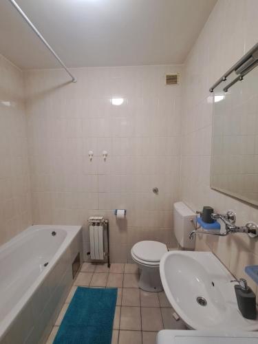 a bathroom with a tub and a toilet and a sink at Apartment Rony in Zagreb