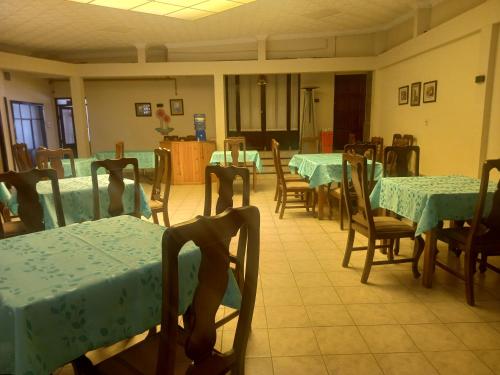 une salle à manger avec tables et chaises et nappes vertes dans l'établissement HOTEL NOBLEZA, à Potosí