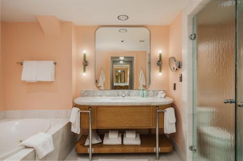 a bathroom with a sink and a tub and a mirror at Hotel Bardo Savannah in Savannah