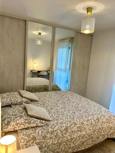 une chambre avec un lit et un grand miroir dans l'établissement Appartement 10 mn de Paris et 5 mn du terminus Paris-Bauvais, à Saint-Denis