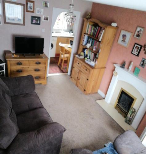 a living room with a couch and a fireplace at Lawford Close in Madeley