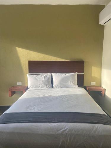 a bed with two pillows and two tables on it at REGMAR Progreso Yucatán in Progreso