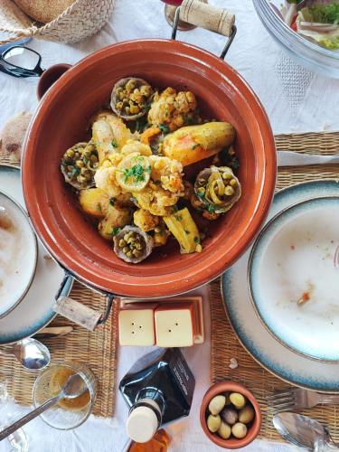 a bowl of food with mushrooms and a bowl of soup at Hôte sahara & spa TADIGHOUST in El Hara