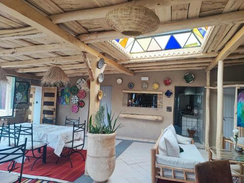 a living room with a table and chairs and a ceiling at Hôte sahara & spa TADIGHOUST in El Hara