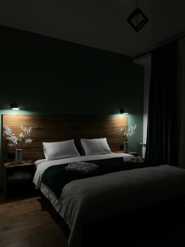 a bedroom with a large bed with a wooden headboard at Hotel Grand View in Stepantsminda