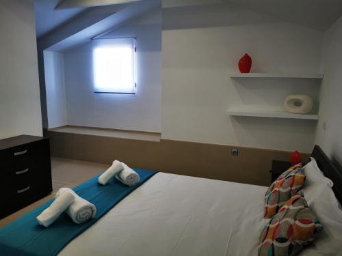 1 dormitorio con 1 cama con toallas en Alojamento M.A., en São Roque do Pico