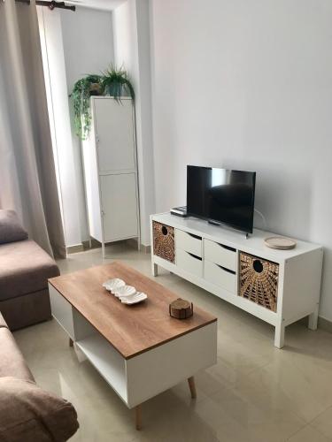 a living room with a tv and a coffee table at Apartamento Isla San Andrés in Carboneras