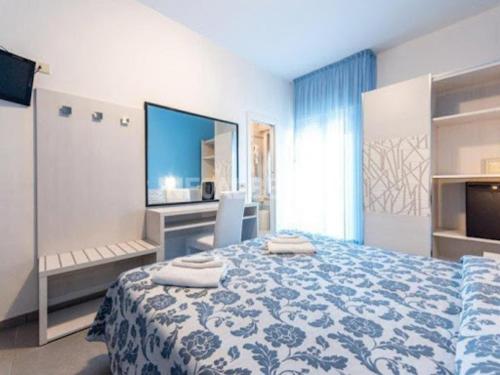 a bedroom with a blue and white bed and a tv at Hotel President in Cesenatico