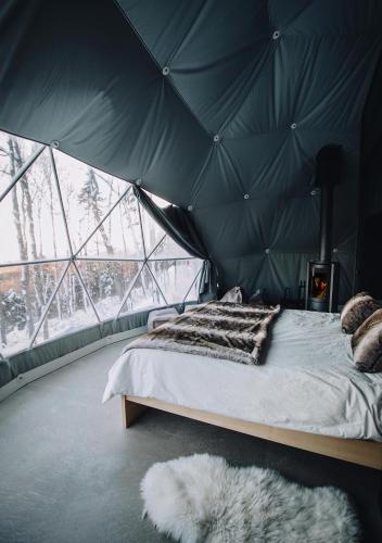 a bedroom with a bed in a tent at Dômes Charlevoix in Petite-Rivière-Saint-François
