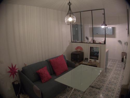 un salon avec un canapé bleu avec des coussins rouges dans l'établissement Beauty of Paris, à Paris