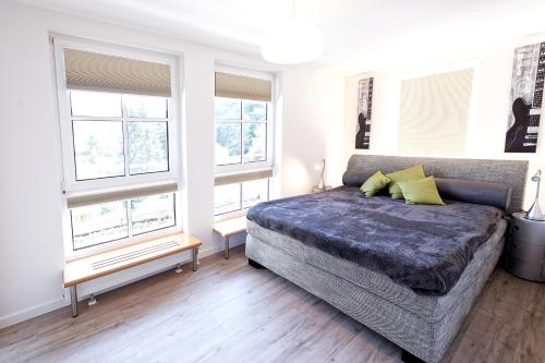 1 dormitorio con 1 cama y algunas ventanas en Großzügiges helles Penthouse mit Balkon in ruhiger Lage en Kulmbach