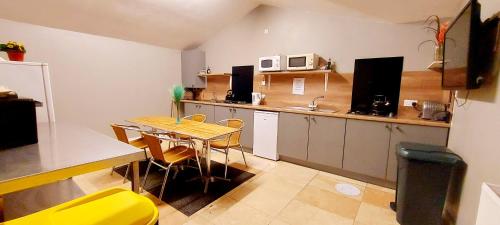 a small kitchen with a table and a yellow chair at Private Room at Torrent Walk Bunkhouse in Snowdonia in Dolgellau