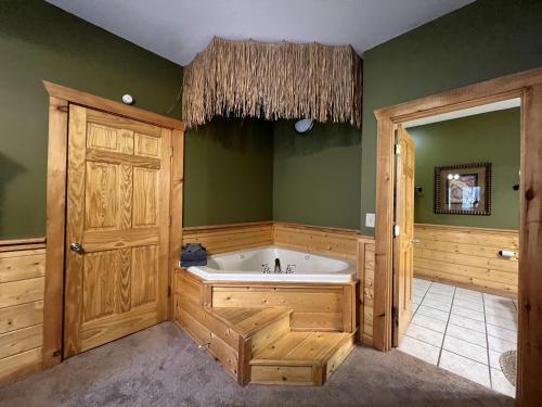 a large bathroom with a tub and green walls at Airport Runway 33 in Pigeon Forge