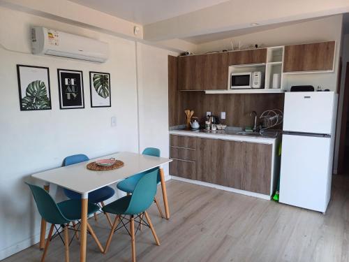 eine Küche und ein Esszimmer mit einem Tisch und Stühlen in der Unterkunft La Demorada, cómoda casa en entorno natural in Mercedes