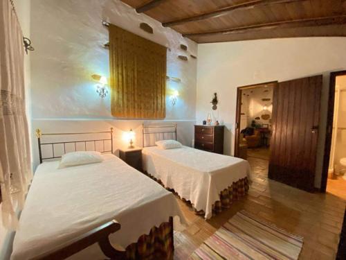 a bedroom with two beds in a room at Serra do Caldeirao Villa with Pool in Curvatos