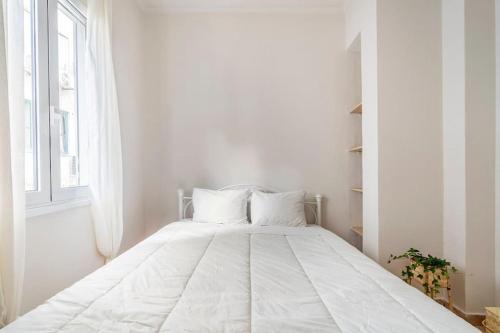 a white bed in a white room with a window at STM Monastiraki Acropolis Apt in Athens