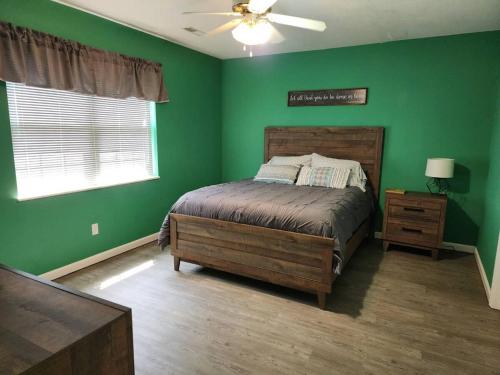 um quarto verde com uma cama e uma ventoinha de tecto em Best spot for you and the family in Sevier County em Pigeon Forge