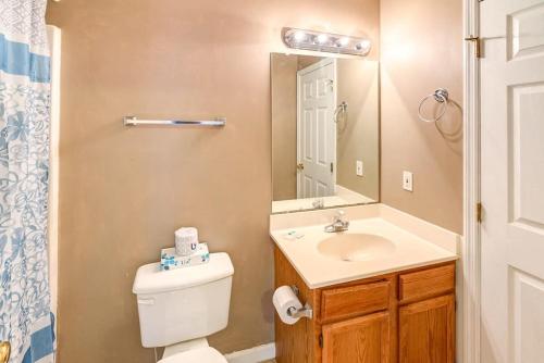 a bathroom with a toilet and a sink and a mirror at Best spot for you and the family in Sevier County in Pigeon Forge