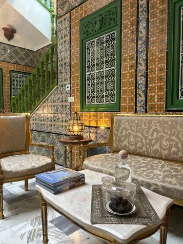 a living room with a table and a couch and chairs at Dar Waya in Mahdia