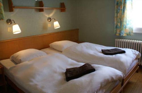 two beds in a room with towels on them at The Holiday Home Davos in Davos