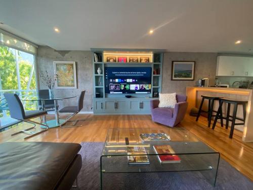 a living room with a tv and a table at Casa Gama Marcel - Top Design & Art en Polanco in Mexico City