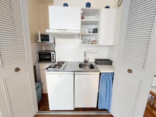 une petite cuisine avec des armoires blanches et un évier dans l'établissement Résidence Le Chateau Durieux 1 - Studio spacieux en plein centre ! MAE-7364, à Aix-les-Bains