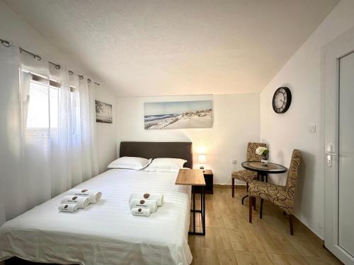 a bedroom with a bed and a table and a clock at Apartments Pribilovic in Budva