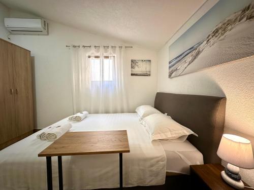 una camera da letto con un letto, un tavolo e una finestra di Apartments Pribilovic a Budua