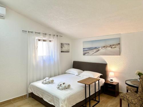 a bedroom with a bed and a table and a window at Apartments Pribilovic in Budva