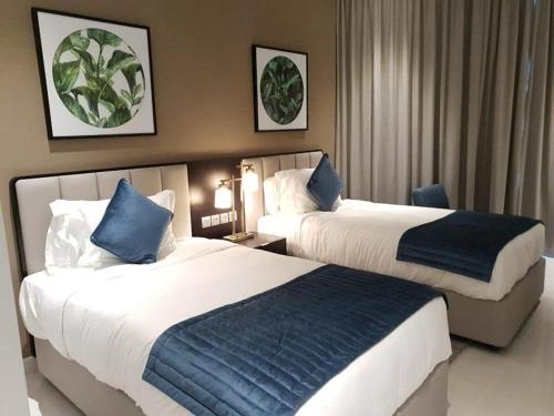 una camera d'albergo con due letti con cuscini blu di Lovely 2/ Bedroom apartment a Dubai