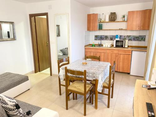 uma cozinha e sala de jantar com mesa e cadeiras em Apartmani Nede em Trogir