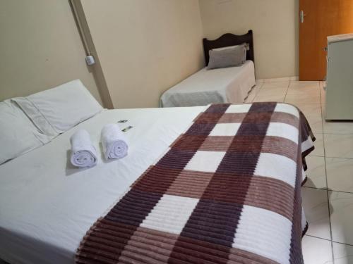 a hotel room with a bed with towels on it at Casa de hóspedes em Capão Bonito c/ Wi-Fi in Capão Bonito