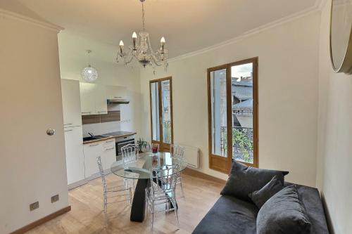 ein Wohnzimmer mit einem Sofa und einem Glastisch in der Unterkunft Appartement de charme avec balcon au pied des commerces in Béziers