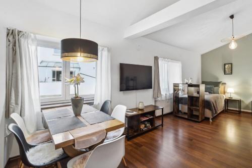 a living room with a dining table and a bedroom at Zigarrenhof Apartment in Citynähe inkl. Netflix in Aschaffenburg