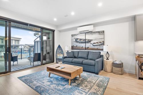 a living room with a couch and a table at Seas The Day Saratoga at THE BEACH HOUSE in Campbell River