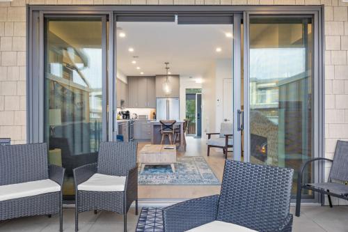 a patio with chairs and a table and a kitchen at Seas The Day Saratoga at THE BEACH HOUSE in Campbell River