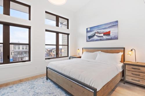 a bedroom with a bed and two windows at Seas The Day Saratoga at THE BEACH HOUSE in Campbell River