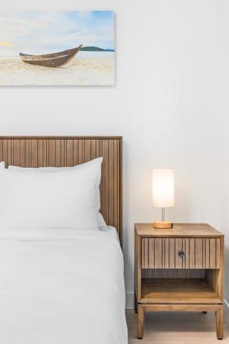 a bedroom with a bed and a table with a lamp at Seas The Day Saratoga at THE BEACH HOUSE in Campbell River