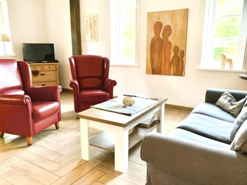 a living room with two chairs and a coffee table at Ahrentschildt's Ferienwohnung im Reetdachhaus in Eyendorf