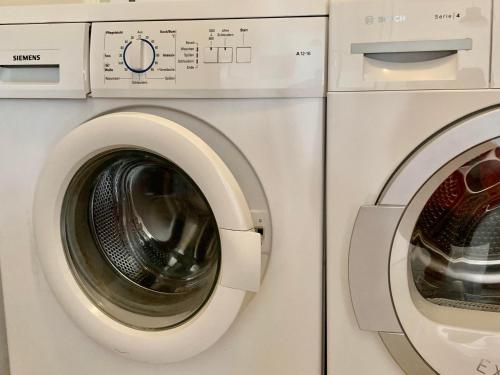 a washing machine and a dryer are next to each other at Ahrentschildt's Ferienwohnung im Reetdachhaus in Eyendorf