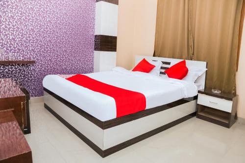 ein Schlafzimmer mit einem großen Bett mit roten Kissen in der Unterkunft OYO Hotel Sonar Gaon in Agartala