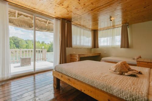 sypialnia z łóżkiem i dużym oknem w obiekcie Kaway Resort & Spa w mieście Tabuelan