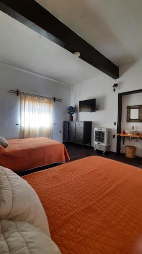 een hotelkamer met 2 bedden met oranje lakens bij Casa Gardenia Hotel in Tecozautla