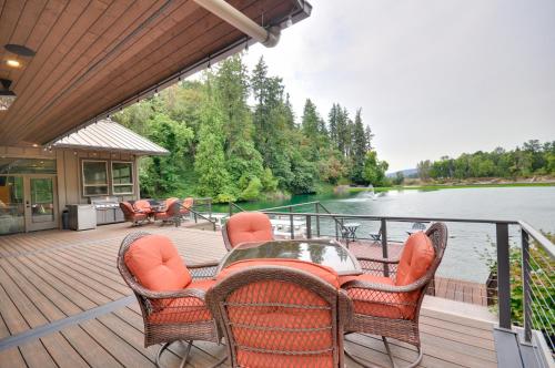 a deck with a table and chairs and a view of a river at Luxurious Waterfront Retreat with Private Pond! in Ridgefield